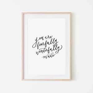 Peut inclure: Impression encadrée avec la citation "You are fearfully wonderfully made" en calligraphie noire sur fond blanc. Le cadre est en bois clair, et l'impression est centrée dans un passe-partout blanc.