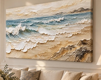 May include: A large rectangular canvas painting featuring a textured impasto seascape. The artwork depicts ocean waves crashing onto a sandy beach with shades of blue, white, beige, and tan. The scene includes a distant shoreline and rocky elements.