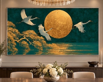 May include: A rectangular wall art piece featuring three white cranes in flight against a deep teal background. A large, textured golden moon sits centrally, with a golden tree branch extending from the left and golden light reflecting on water.
