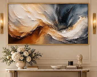 May include: A large rectangular abstract painting in a gold frame featuring thick, textured brushstrokes in shades of deep navy blue, warm amber, cream, and white, mounted on a wall above a marble-topped console table with a beige bench.