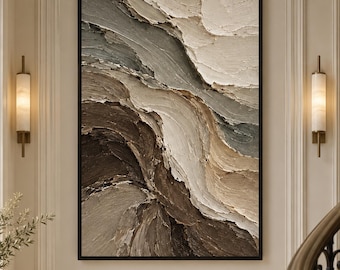 May include: A rectangular wall art piece featuring heavy impasto texture with sweeping, layered strokes in shades of dark brown, beige, cream, and muted gray. The painting is enclosed in a thin black frame and mounted on a neutral wall.