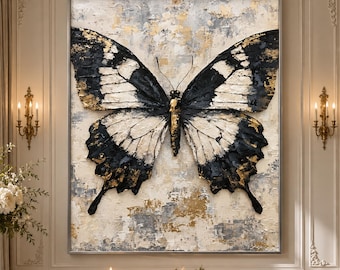 May include: A large rectangular wall painting featuring a central butterfly with black, white, and gold textured wings. The background consists of a layered, abstract mix of cream, gray, and gold paint strokes, creating a heavy impasto effect.