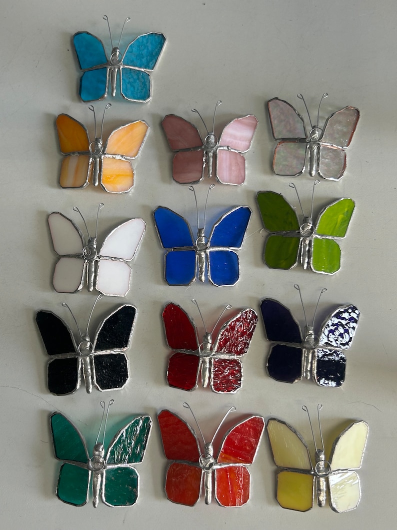Pu&ograve; includere: Assortimento di 12 farfalle in vetro colorato in vari colori, tra cui blu, giallo, rosa, verde, bianco, nero, rosso e crema. Ogni farfalla ha una cornice in filo d'argento.