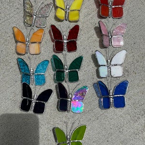 Pu&ograve; includere: Assortimento di 14 farfalle in vetro colorato in vari colori, tra cui giallo, rosso, rosa, blu, verde e iridescente. Ogni farfalla ha una cornice in metallo argentato e misura circa 5 cm.