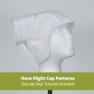 May include: White flight cap pattern with grey lines, displayed on a white mannequin head. The pattern includes a step-by-step tutorial. Hera Flight Cap Patterns. Step-By-Step Tutorial Included!