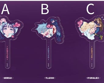 Puede incluir: Tres diseños de abanicos Alien Stage de acrílico con ilustraciones de estilo anime. Cada abanico presenta un diseño de personaje diferente con un elemento en forma de corazón. Los abanicos tienen un mango transparente y el texto "ALIEN STAGE" está impreso en el mango.