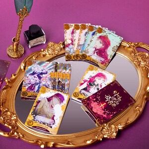 May include: A collection of trading cards featuring illustrations of characters from the Korean webtoon "The Remarried Empress". The cards are displayed on a gold-colored tray with a mirror surface. The cards have a holographic finish and feature the text "The Remarried Empress" in Korean.