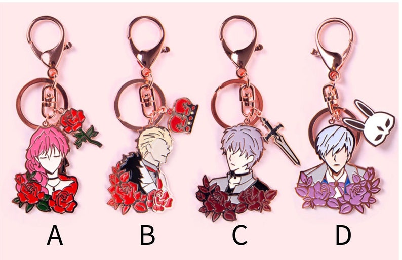 May include: Four different rose-themed keychains featuring anime characters. Each keychain has a gold-colored metal ring and a charm with a different character, including a pink-haired woman, a blonde man, a silver-haired man with a sword, and a silver-haired man with a rabbit mask.