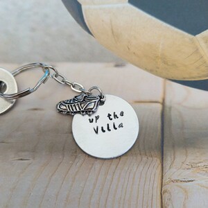 May include: Silver keyring with a small silver boot charm and a round silver tag that says "Up the Villa".