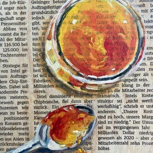 May include: A close-up of a painting of two spoons with yellow, orange, and red paint. The spoons are on top of a page of text that reads "Reform des Stromsystems".