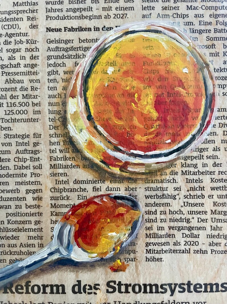 May include: A close-up of a painting of two spoons with yellow, orange, and red paint. The spoons are on top of a page of text that reads "Reform des Stromsystems".