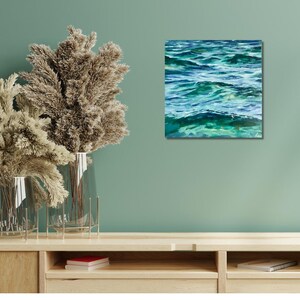 May include: A painting of a turquoise blue ocean with whitecaps and ripples. The water is painted in a realistic style with visible brushstrokes.