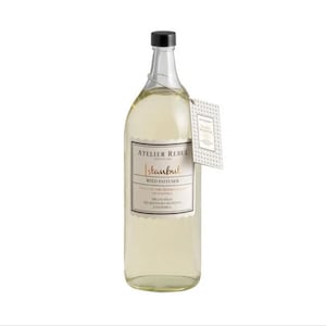 Puede incluir: Una botella de vidrio transparente con una etiqueta dorada que dice "Atelier Rebul Istanbul Reed Diffuser". La etiqueta tiene un diseño dorado y blanco y el texto "Descubre los secretos ocultos de Estambul" está impreso en la etiqueta.