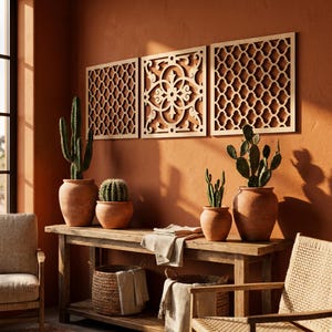 May include: A warm-toned interior scene featuring a wooden console table with terracotta pots holding cacti. Three decorative wooden panels with intricate cut-out designs hang on the wall above. Woven baskets and chairs complete the decor.