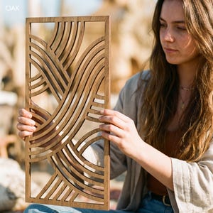 May include: A rectangular wooden wall art piece with a repeating wave pattern. The art is made of light brown wood and has a geometric design. The word "OAK" is in the upper left corner.
