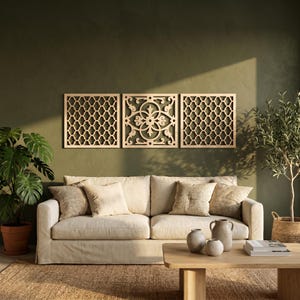 May include: Three wooden wall panels with intricate geometric and floral designs are mounted on a green wall above a cream-colored sofa. The panels are made of light-colored wood and add a decorative touch to the living room.