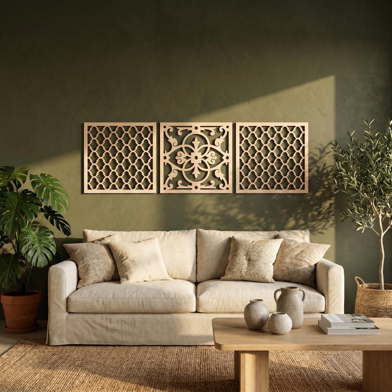 May include: Three wooden wall panels with intricate geometric and floral designs are mounted on a green wall above a cream-colored sofa. The panels are made of light-colored wood and add a decorative touch to the living room.
