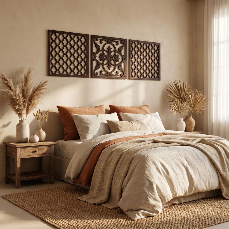 May include: A bedroom scene featuring a bed with a beige comforter and rust-colored accents. Decorative wooden panels hang above the bed. A wooden nightstand with a drawer and vases with dried plants complete the warm, inviting aesthetic.