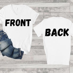 May include: White V-neck t-shirt with the word "FRONT" printed in black. A pair of blue denim jeans is next to the shirt. The back of a white t-shirt with the word "BACK" printed in black is also shown.