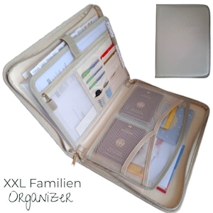 Könnte beinhalten: Beigefarbener Reißverschluss-Organizer mit mehreren Fächern, darunter Kartenfächer, Netztaschen und Dokumentenhalter. Der offene Organizer zeigt verschiedene Dokumente, Karten und Pässe. Ein kleinerer, geschlossener Organizer ist rechts oben abgebildet. Text: "XXL Familien ORGANIZER."