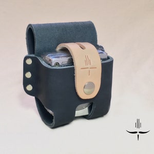 Puede incluir: Una funda de c&aacute;mara de cuero negro con una correa de cuero marr&oacute;n y un cierre de presi&oacute;n plateado. La funda tiene una superficie texturizada y est&aacute; dise&ntilde;ada para adaptarse a una c&aacute;mara peque&ntilde;a.