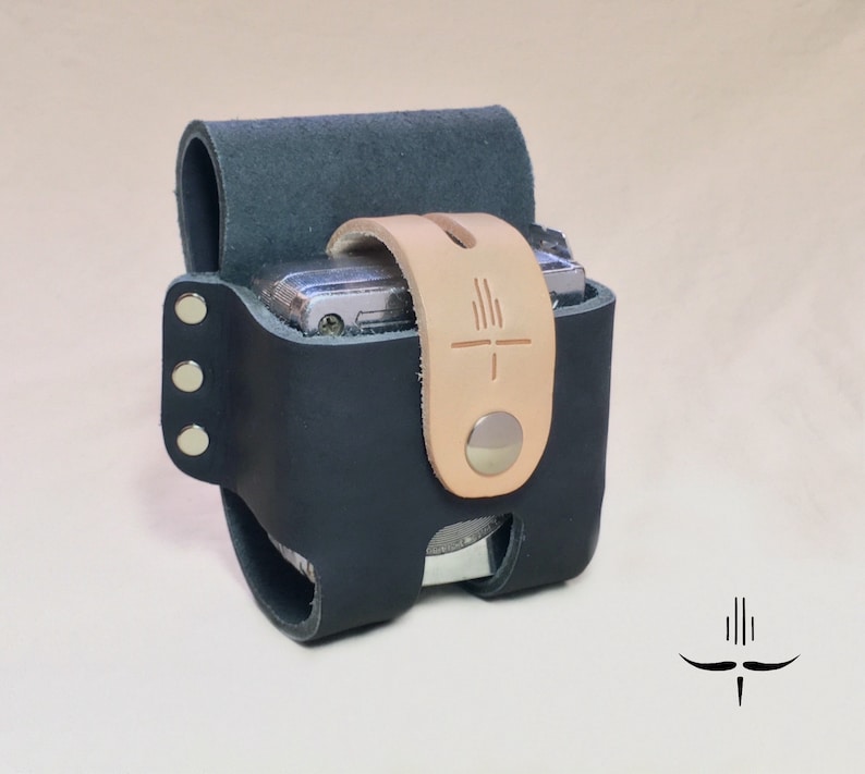 Puede incluir: Una funda de c&aacute;mara de cuero negro con una correa de cuero marr&oacute;n y un cierre de presi&oacute;n plateado. La funda tiene una superficie texturizada y est&aacute; dise&ntilde;ada para adaptarse a una c&aacute;mara peque&ntilde;a.
