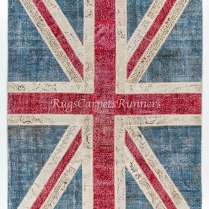 May include: A vintage-style rug featuring the Union Jack flag design. The rug is made of patchwork fabric in shades of blue, red, and white. The rug has a distressed look, with faded colors and visible stitching.