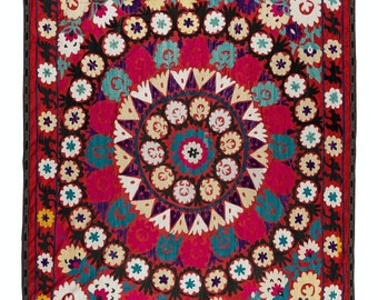 May include: A red, black, and white embroidered textile with a circular pattern of flowers and geometric shapes.