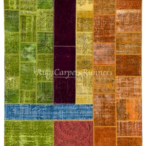 Puede incluir: Una alfombra de patchwork colorida con cuadrados de verde, azul, rojo, naranja y morado. La alfombra tiene un aspecto desgastado y vintage.
