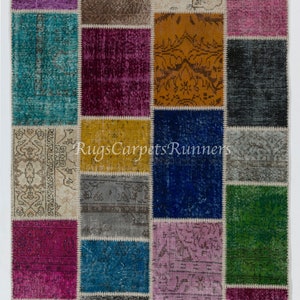 May include: A patchwork rug with a variety of colors and patterns, including blue, green, purple, pink, and yellow. The rug is made of recycled materials and has a unique, handmade look.