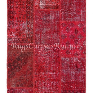 Może przedstawiać: Czerwony dywan patchwork z różnymi wzorami i projektami. Dywan jest wykonany z materiałów pochodzących z recyklingu i idealnie nadaje się do dodania koloru i faktury do każdego pomieszczenia.