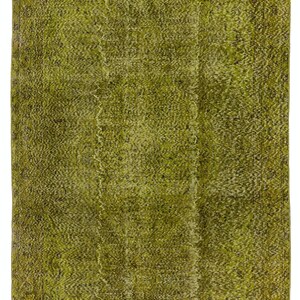 May include: A green vintage rug with a faded pattern. The rug has a distressed look and is made of a soft, woven material.