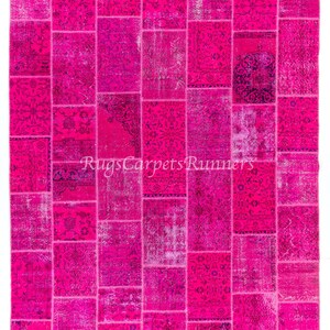 May include: A pink patchwork rug with a variety of floral patterns. The rug is made up of many different squares of fabric, each with a unique design. The rug is perfect for adding a touch of color and style to any room.
