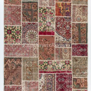 Op de afbeelding: Een patchwork tapijt met een verscheidenheid aan kleuren en patronen. Het tapijt is gemaakt van veel verschillende stukken stof die aan elkaar zijn genaaid. Het tapijt heeft een rustieke en vintage uitstraling.