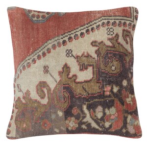 Puede incluir: Cojín cuadrado con un diseño de alfombra vintage. El cojín presenta una mezcla de colores, incluyendo rojo, beige, marrón y negro. El diseño tiene patrones intrincados y motivos florales, agregando un toque de elegancia a cualquier habitación.