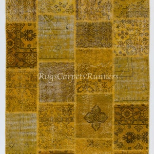 May include: A patchwork rug in a yellow and brown colour scheme. The rug is made from different pieces of fabric that have been sewn together. The rug has a vintage look and feel.