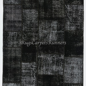 May include: A rectangular, black and gray patchwork rug with a distressed, vintage appearance. The rug features a repeating pattern of rectangular blocks with varying textures and shades of gray. The text "RugsCarpetsRunners" is visible.