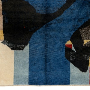 May include: Abstract rug with geometric shapes in shades of blue, black, white, red, and yellow.