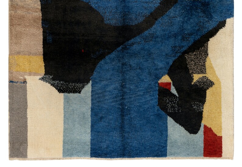 May include: Abstract rug with geometric shapes in shades of blue, black, white, red, and yellow.