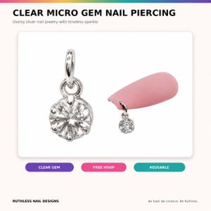 Könnte beinhalten: Ein silberfarbener Nagel-Piercing-Anhänger mit einem klaren, rund geschliffenen facettierten Edelstein in einer Metallfassung. Der Anhänger verfügt über einen kleinen runden Ring zur Befestigung, der sowohl einzeln als auch an einem hellrosa Kunstnagel gezeigt wird.