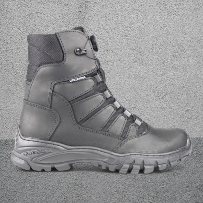 May include: A single black work boot with a high ankle and a rugged sole. The boot features a lace-up design with reinforced panels and the brand name "UBOTSHOES" is visible. The sole has the brand name "TREX" embossed.