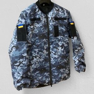 Side angle of blue pixel Greta jacket – reinforced shoulders – adjustable cuffs and durable zipper – practical outdoor design