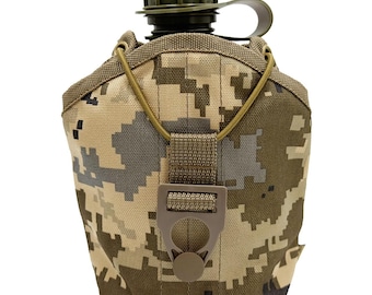 Op de afbeelding: Een militaire veldfles met een digitaal camouflagepatroon. De veldfles heeft een groene dop en een hoes met een pixelpatroon in beige, groen en grijs. Het bevat een riem en een gesp voor veilig dragen.