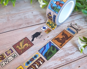 May include: Decorative washi tape featuring medieval-style illustrations of animals and figures in colorful rectangular frames. The tape roll is beige with a repeating pattern of various designs, including a raven, griffin, and rabbit.