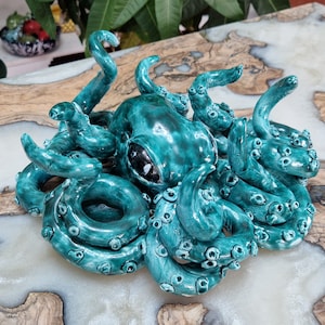 May include: A teal blue ceramic octopus sculpture with detailed tentacles and a textured surface.