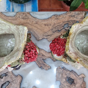 May include: Two ceramic flower pots with a green and white glaze. Each pot has a cluster of red berries and a green leafy design. The pots are empty and ready for planting.