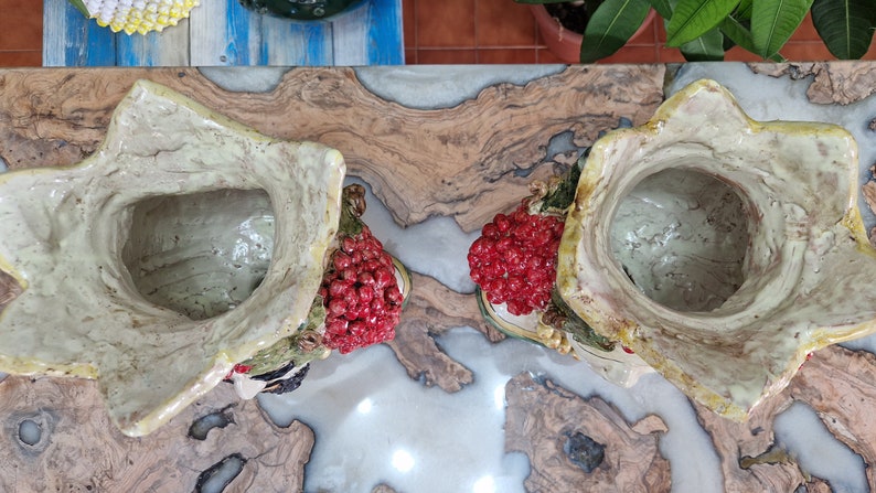 May include: Two ceramic flower pots with a green and white glaze. Each pot has a cluster of red berries and a green leafy design. The pots are empty and ready for planting.
