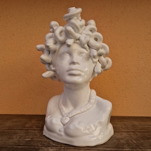 Può includere: Busto in ceramica bianca di Medusa con serpenti per capelli. Il busto è dettagliato con una collana e una finitura liscia e lucida.