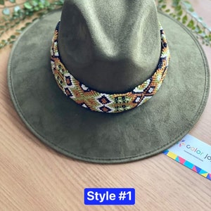 May include: A green felt fedora hat with a colourful beaded band. The band features a geometric pattern in shades of green, orange, white, and black. The hat is labelled "Style #1".