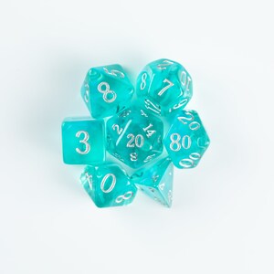 May include: A set of seven turquoise dice with silver numbers. The dice are a d4, d6, d8, d10, d%, d12, and d20.